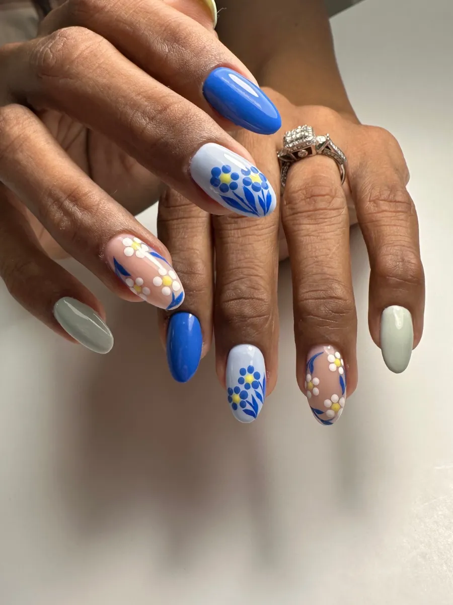 Flores azules y blancas pintadas a mano con uñas cobalto, celeste y salvia