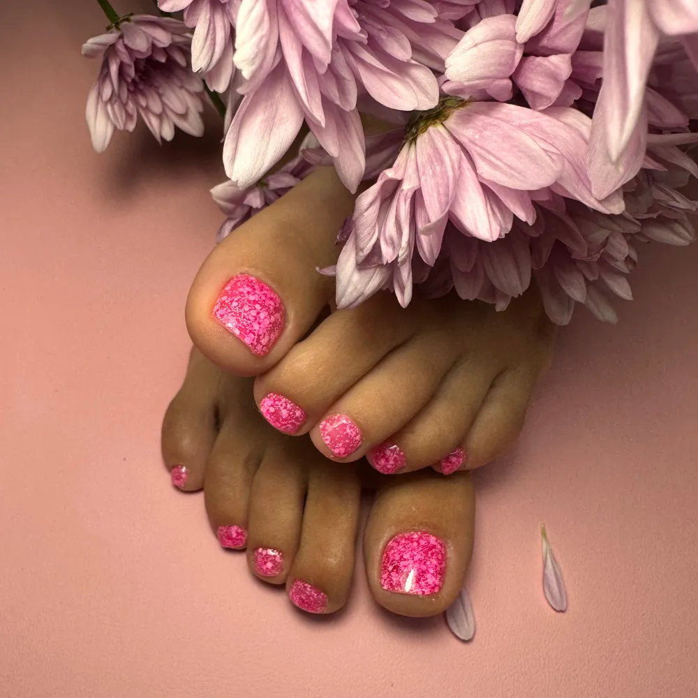Pink glitter gel pedicure with lilac chrysanthemums